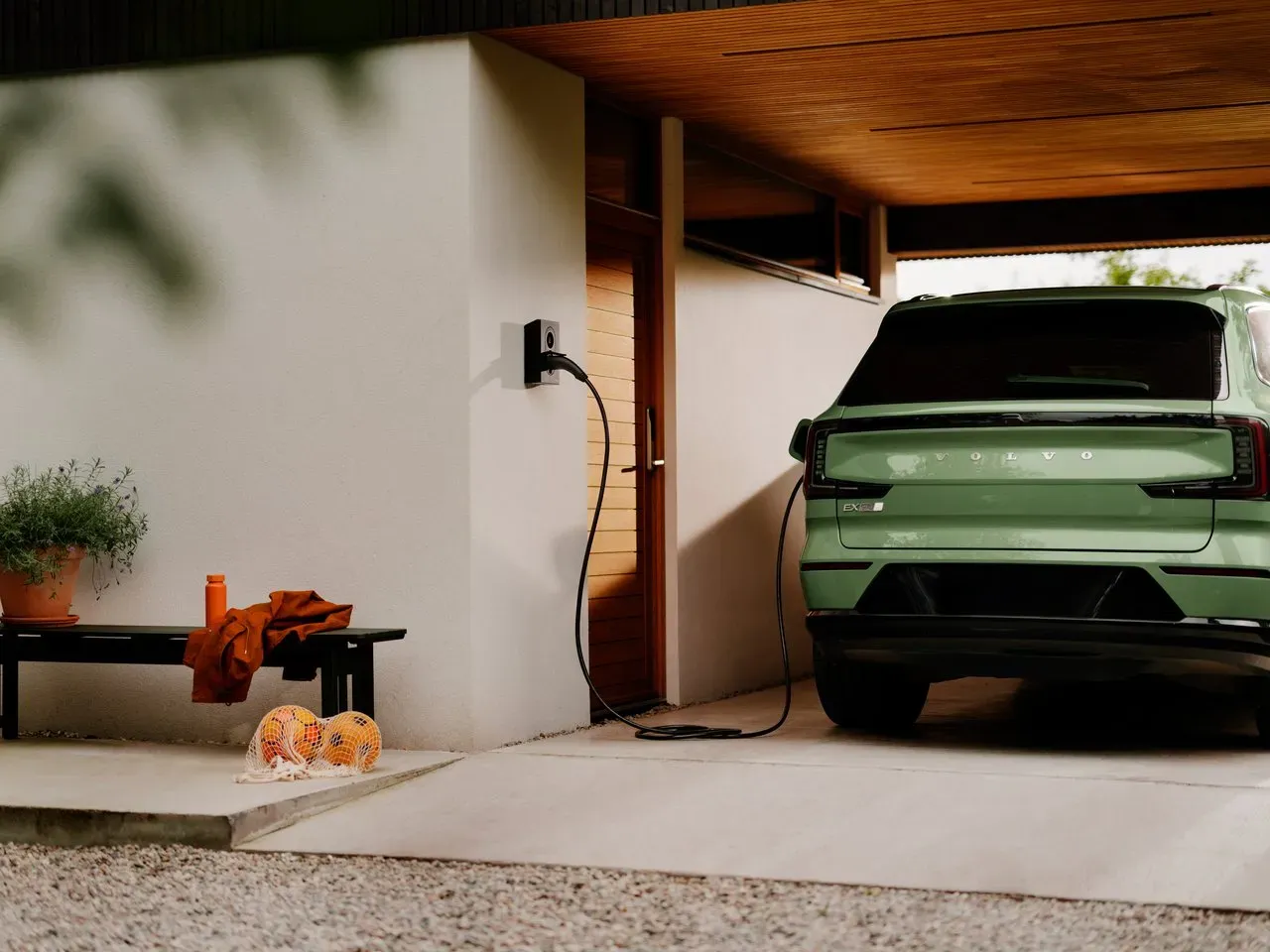 Grünes Elektrofahrzeug lädt an einer Wallbox in Hausgarage.