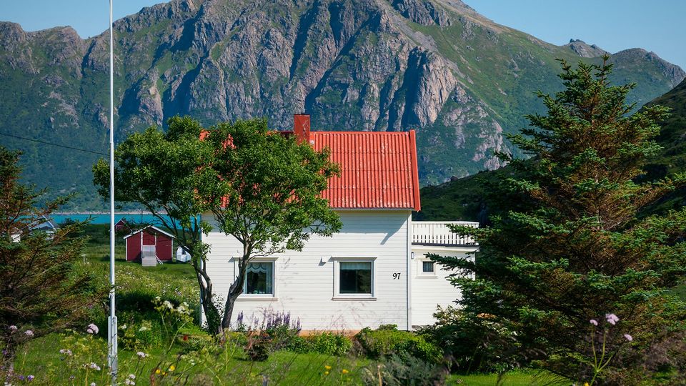 Bilde av et hvitt hus med et stort fjell i bakgrunnen.