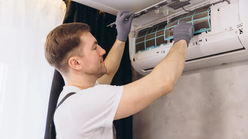 Installatør monterer en varmepumpe-indedel.