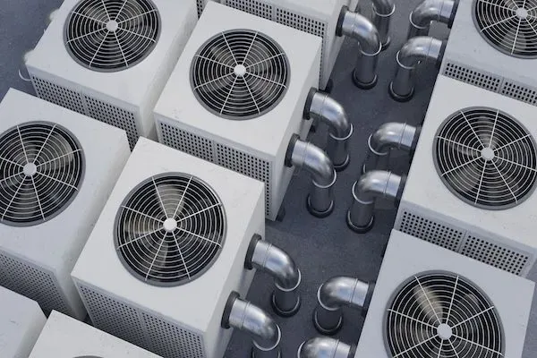 Più unità di condizionamento d'aria bianche con ventilatori e tubature metalliche.