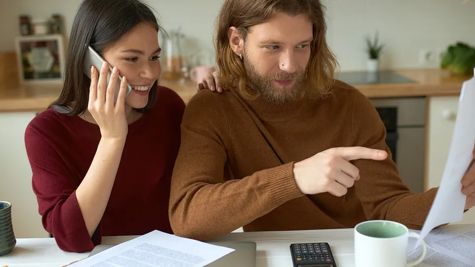 Couple reviewing documents together while one points at paper.