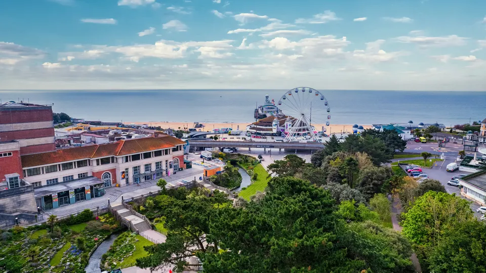 Aerial view of Bournemouth seafront with pier and Ferris wheel overlooking the beach and ocean.