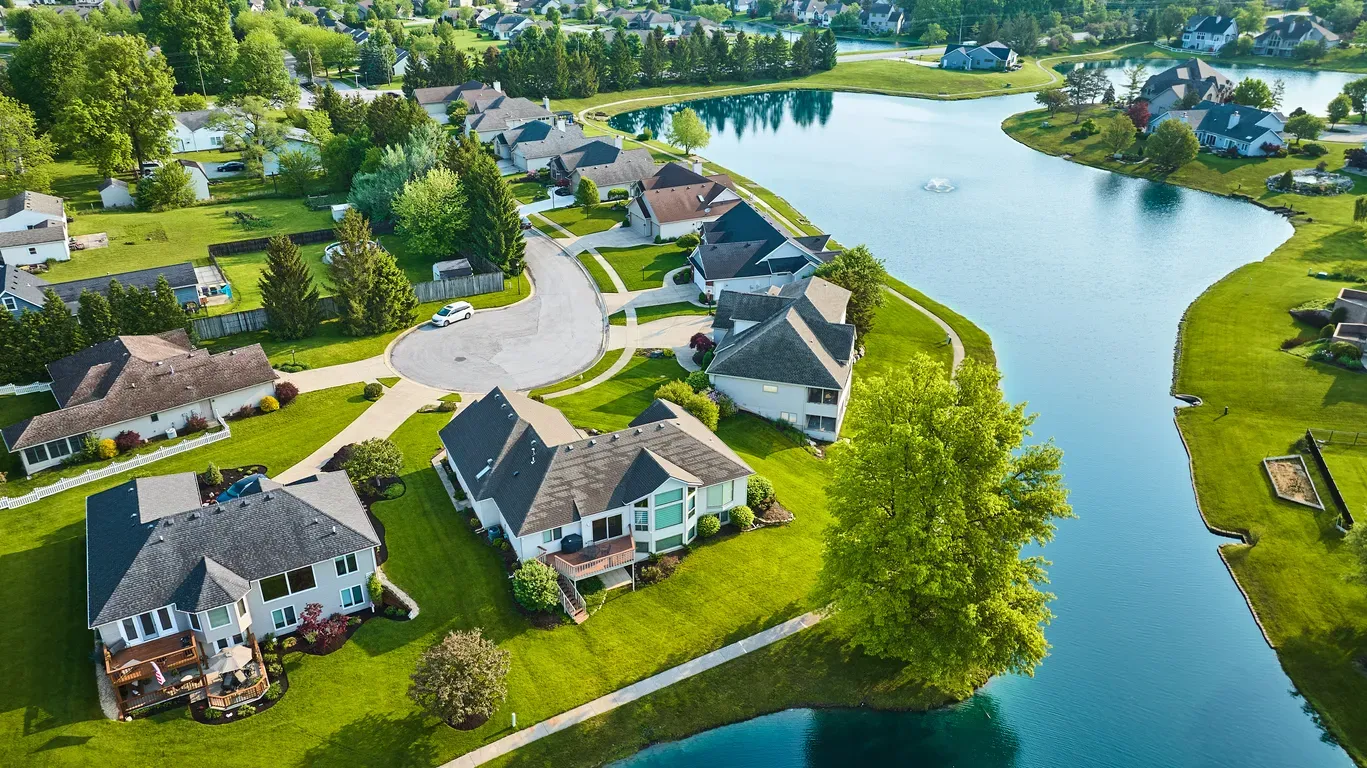 Dronebilde av boliger, nærområde og vann som er tatt i forbindelse med et boligsalg
