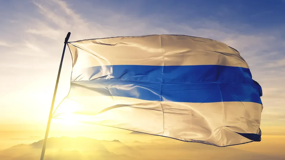Blau-weiss gestreifte Flagge weht in der Abendsonne.