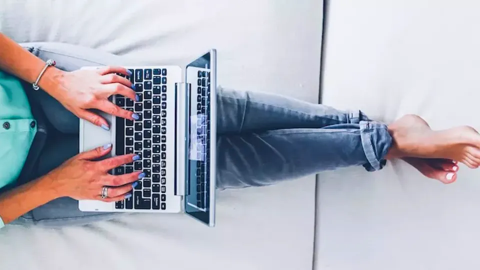Person skriver på bærbar computers tastatur.