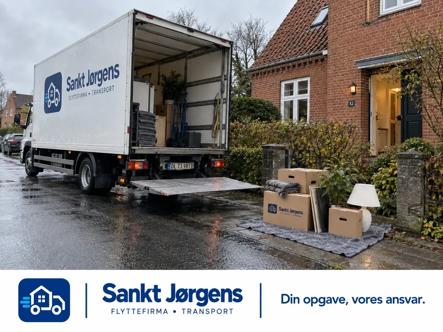 Flyttebil parkeret med kasser stillet ud på fortovet.