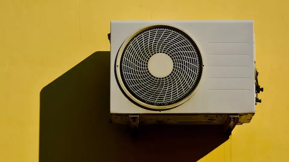 Varmepumpe på en gul mur