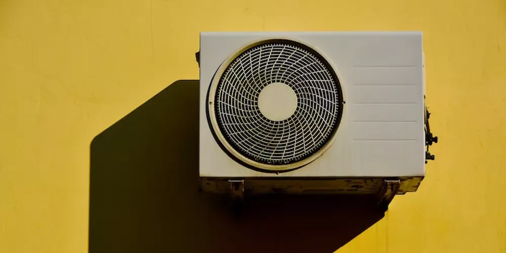 Varmepumpe på en gul mur