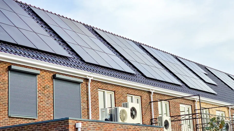 Edificio de ladrillo con paneles solares instalados en techo inclinado.