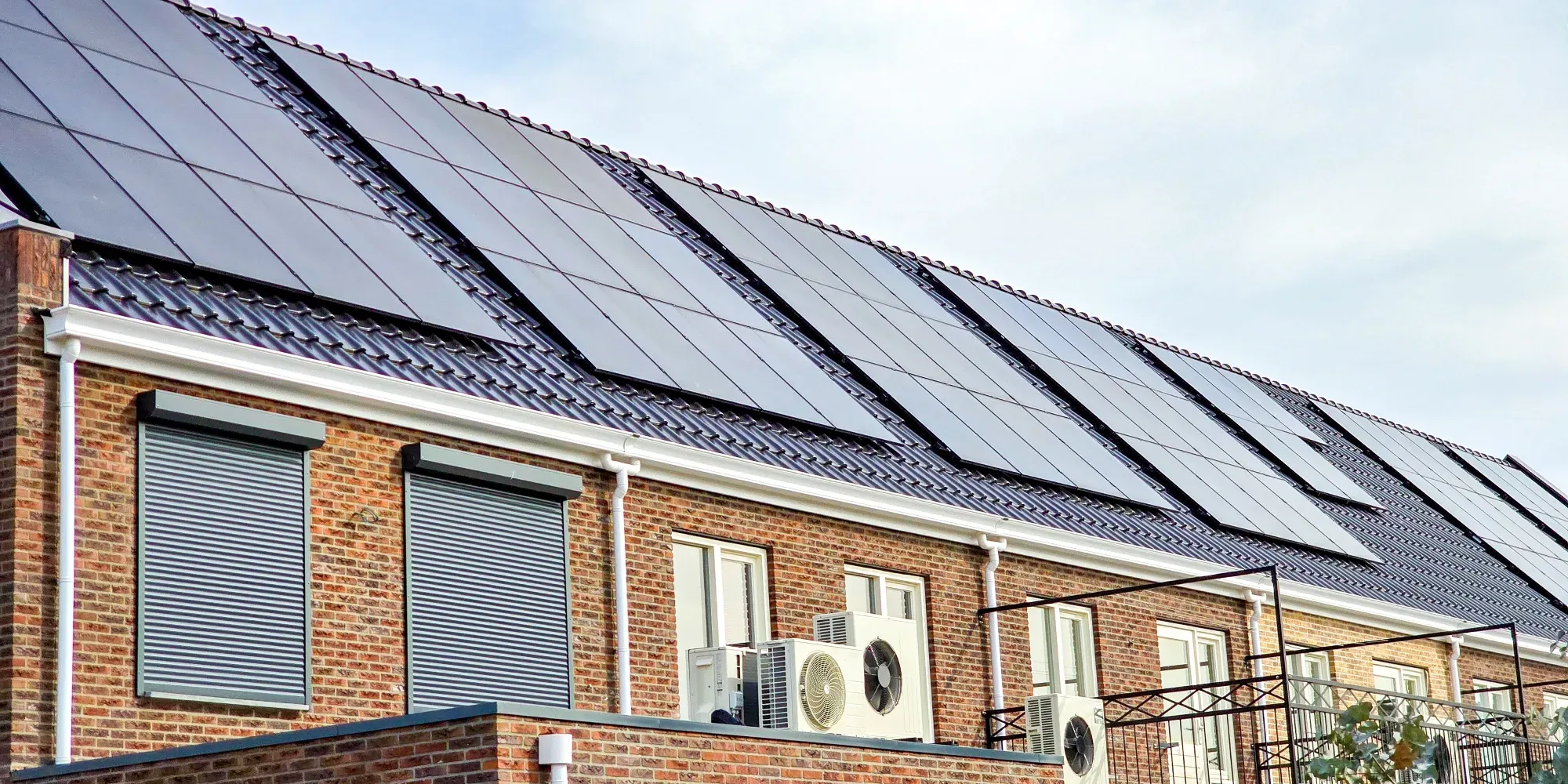 Edificio de ladrillo con paneles solares instalados en techo inclinado.