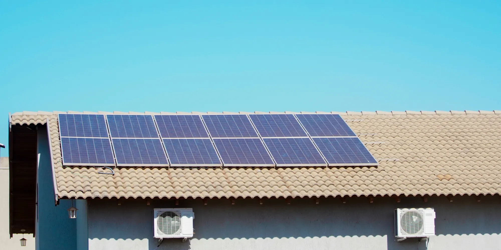 Techo con paneles solares y unidades de aire acondicionado en un edificio.