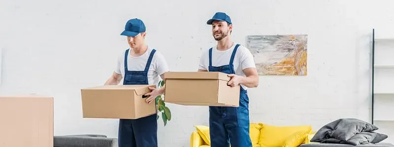 Bilde av to flyttefolk som løfter pappesker i en moderne leilighet