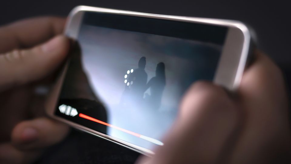 Nærbilde av en mobilskjerm med videoavspilling som buffrer.