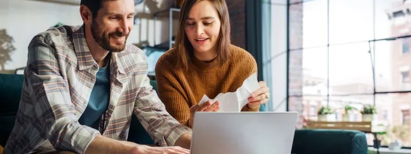 Mand og kvinde sidder foran en computer og kigger på en ny elaftale.