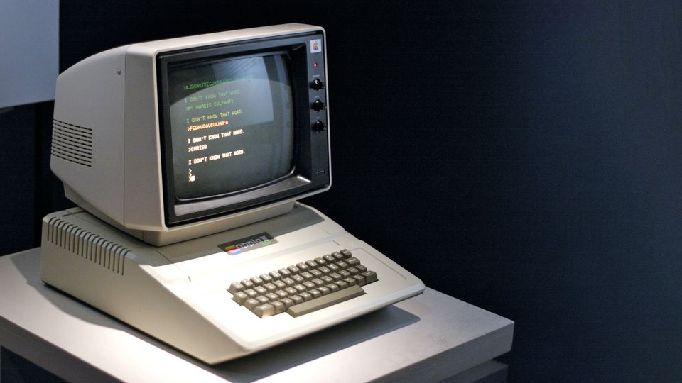 Bilde av en Apple II datamaskin på et lite bord.