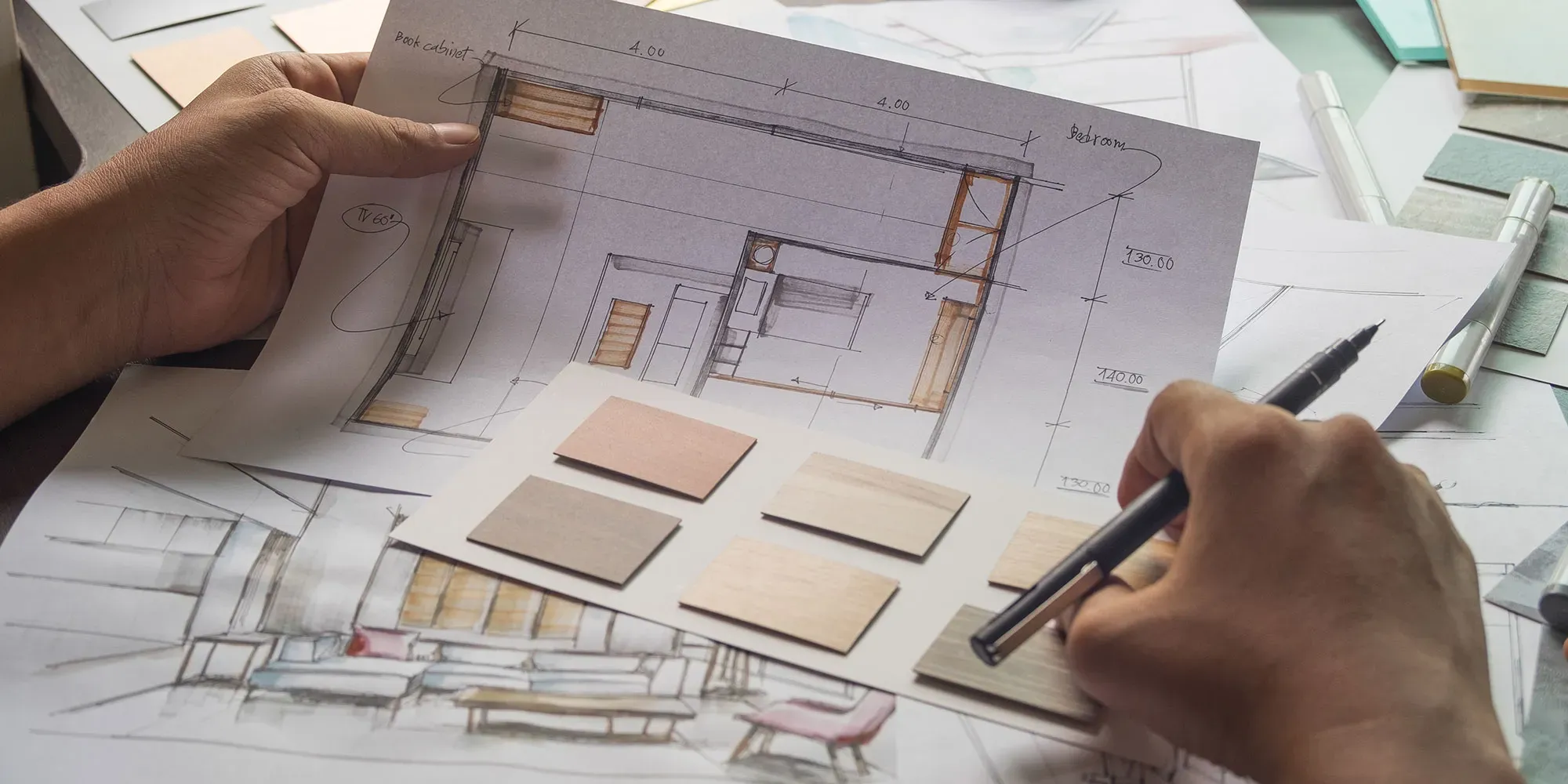 Arkitekt gjennomgår plantegning med materialprøver og penn.
