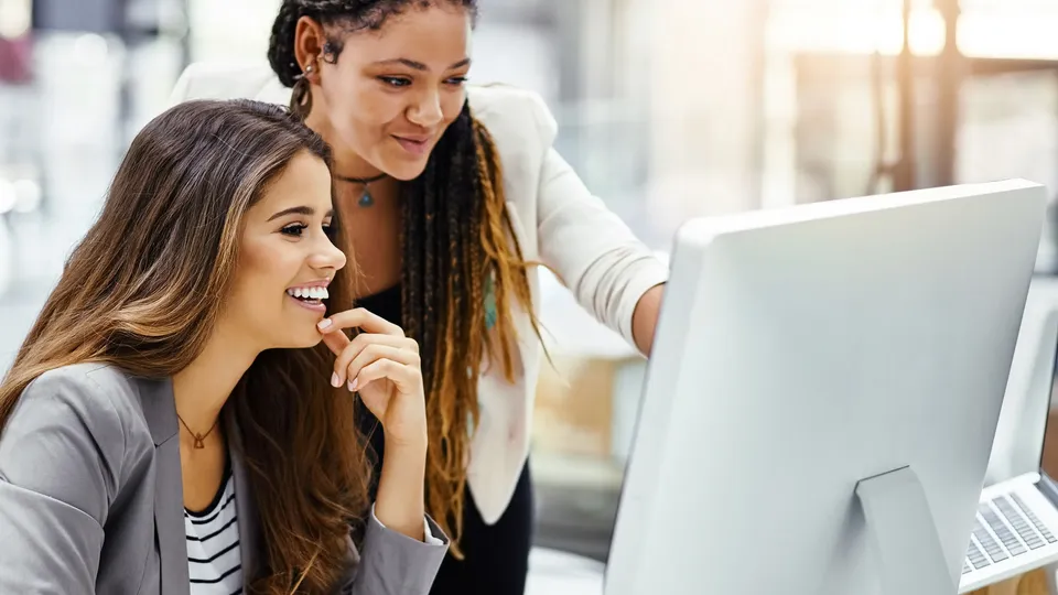 To kvinner ser på en dataskjerm.