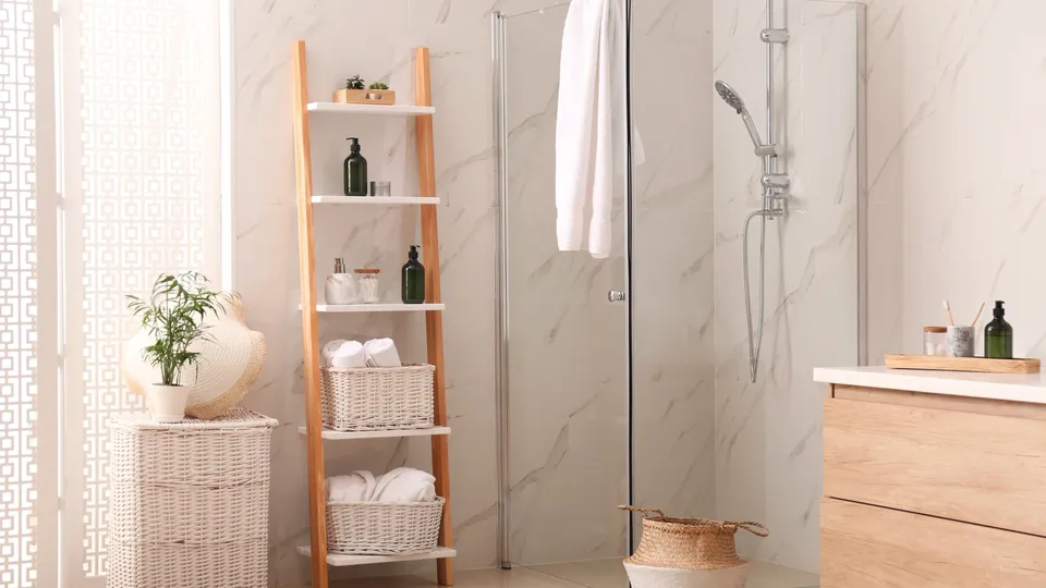 Ljust och modernt badrum med inredning av naturmaterial och dusch med glasdörrar.