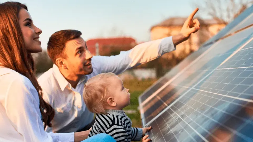 Family pointing at solar panels for Irish homes on a rooftop.