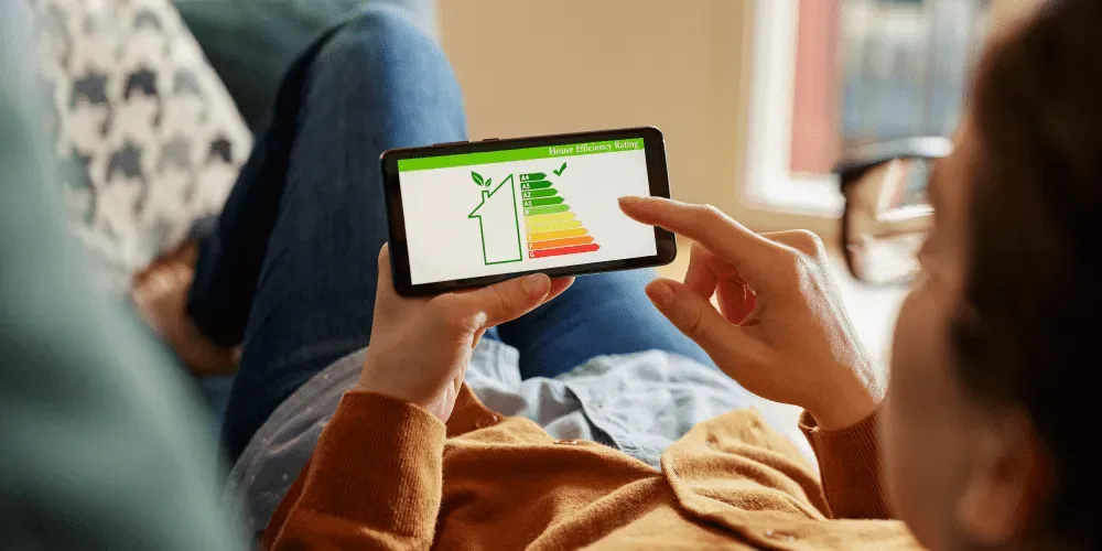 BER certificate and solar panels: Person holding smartphone displaying energy efficiency rating chart.