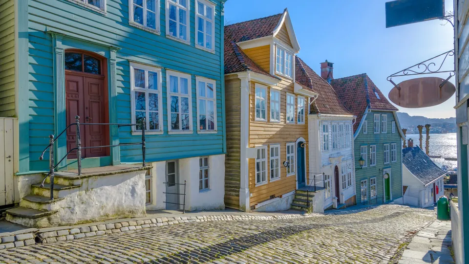 Bergen: Fargerike trehus på brosteinsgate med utsikt over vann.