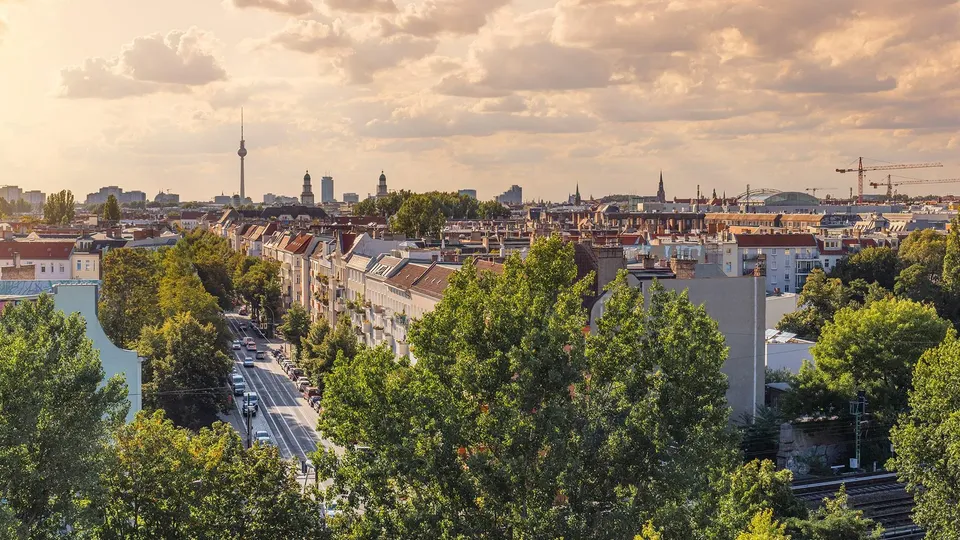 Blick über Dächer und Bäume in Berlin-Friedrichshain bei Sonnenuntergang
