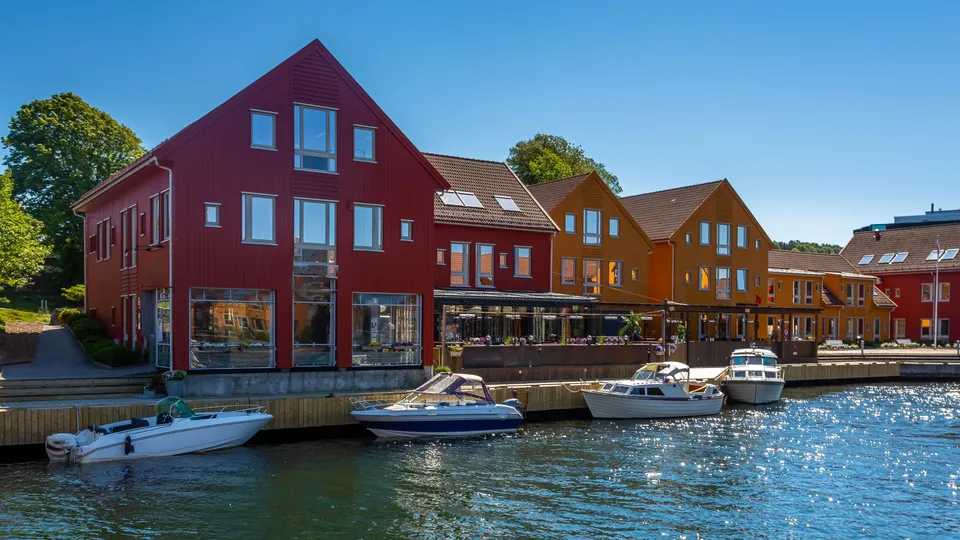 Røde trebygninger og båter langs havnen i Kristiansand