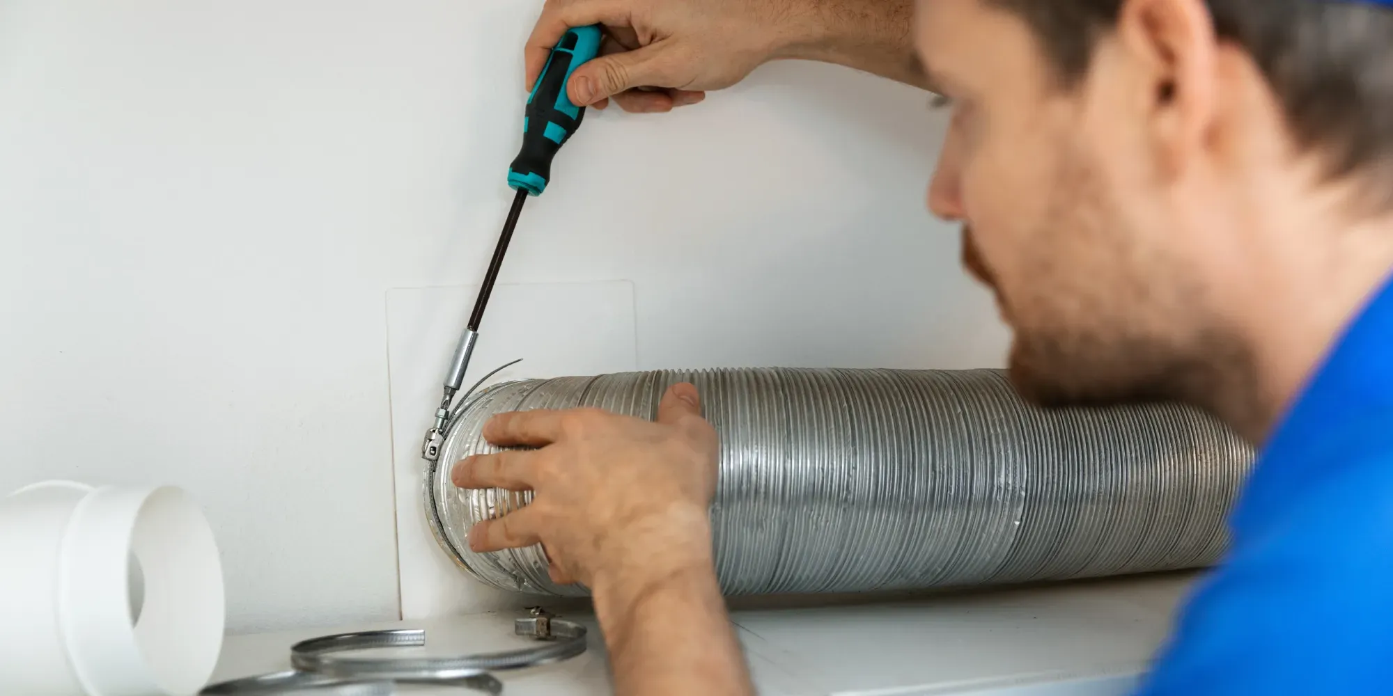 Varmepumpemontør, der fixer et rør på en ventilationsvarmepumpe