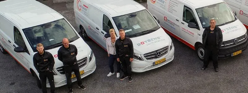 Medarbejdere fra Boysens Varmeteknik foran firmabiler.