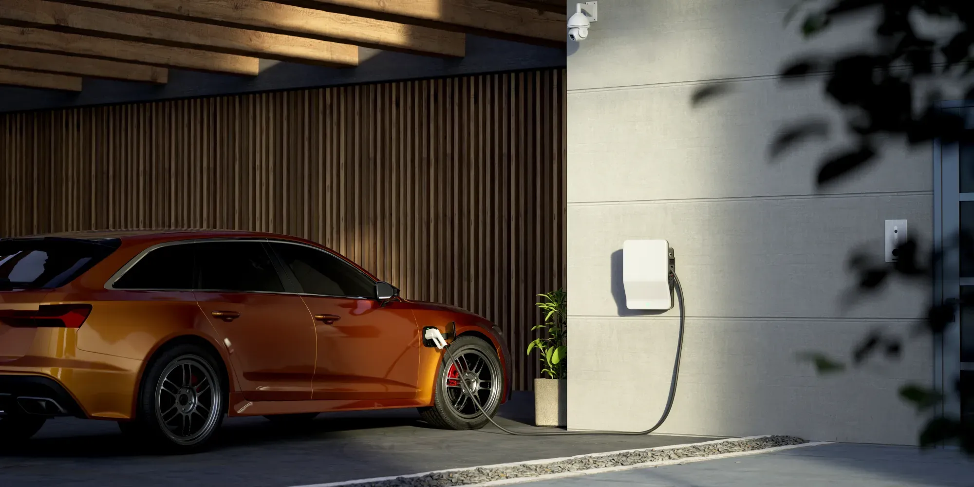 Oransje elektrisk bil som lades ved veggmontert ladestasjonen.