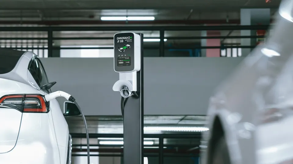 Veículo elétrico carregando em uma estação de parede em um garagem de estacionamento.
