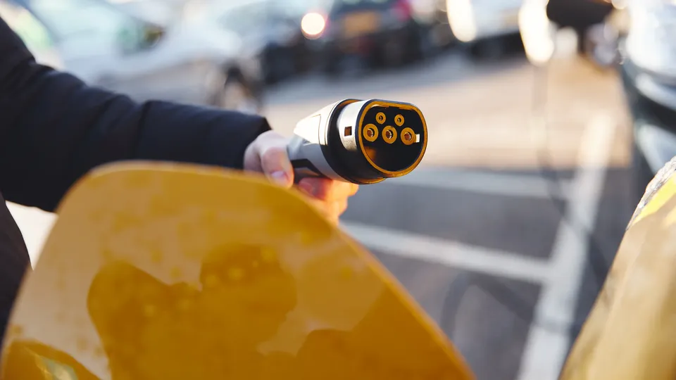 A chademo charger next to a yellow EV