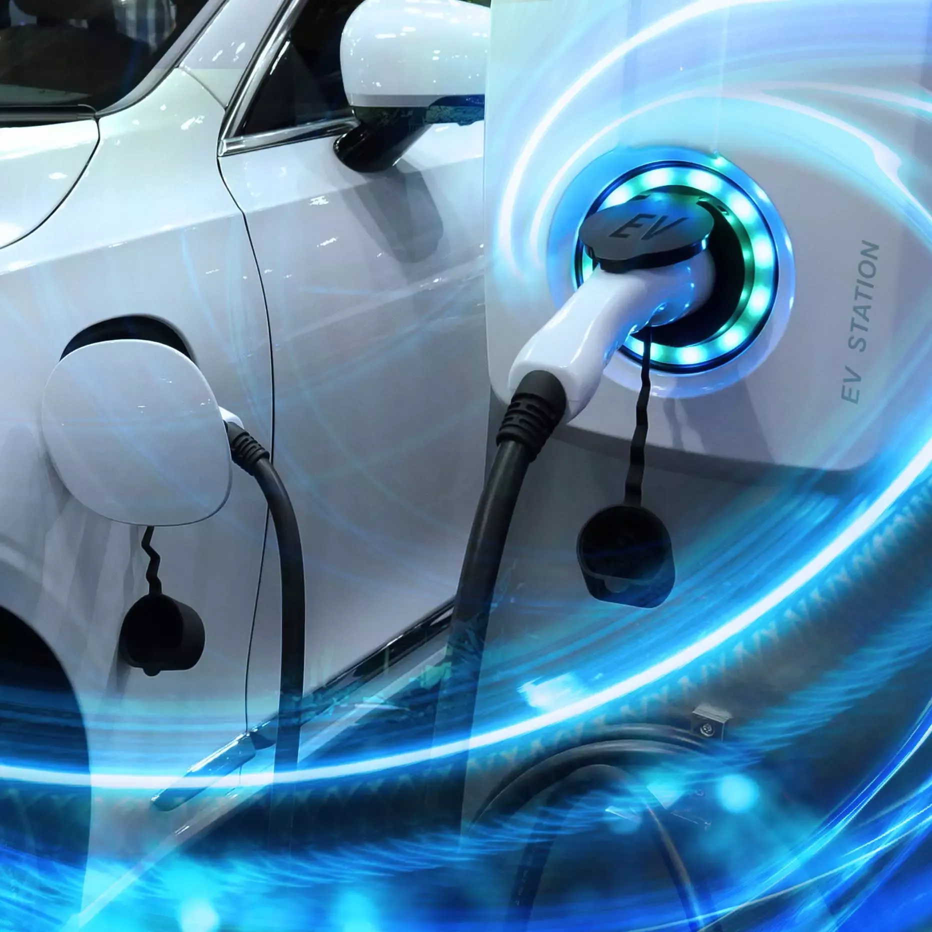 White electric vehicle charging at EV station with illuminated blue charging port.