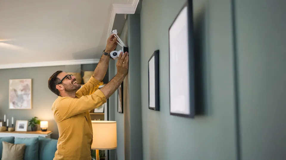 Hombre instalando una alarma en el techo