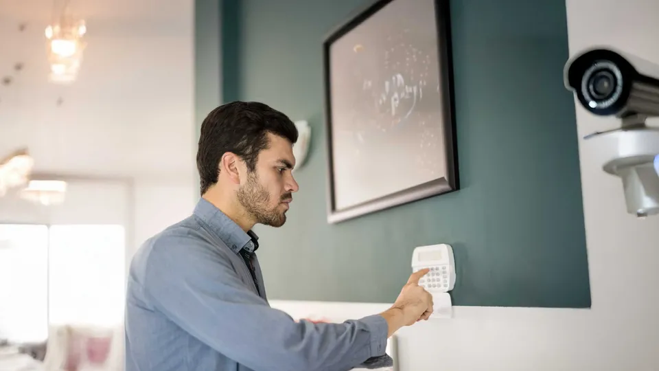 Hombre configurando la alarma en la casa.