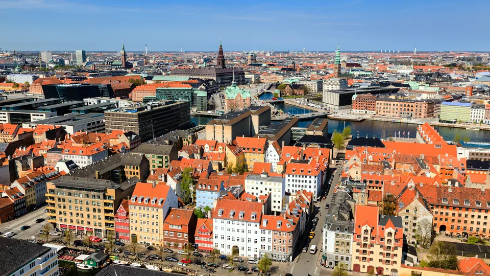 Luftfoto af Københavns bybillede med røde tage og kanaler.
