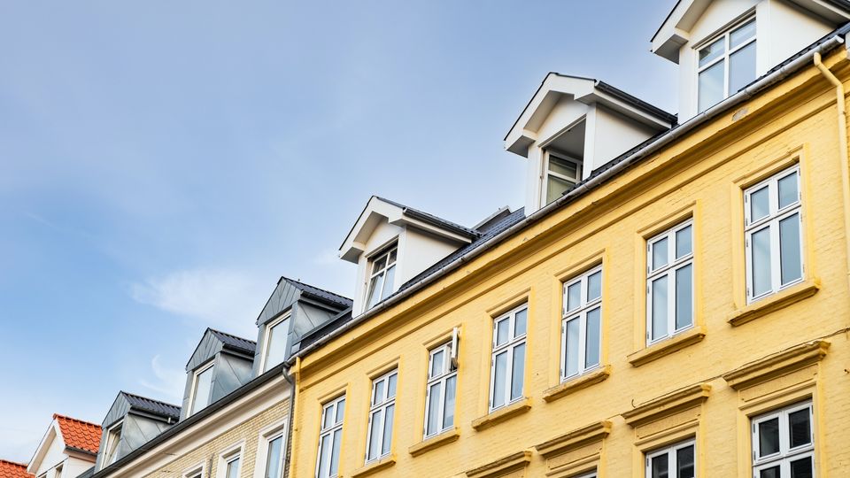 Bilde av en gulmalt bygning med en blå himmel over.