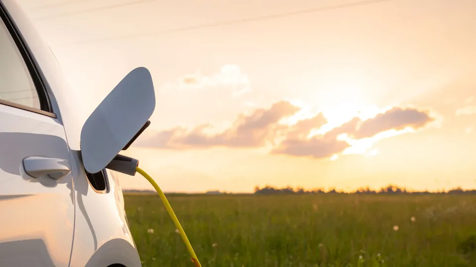 Une voiture électrique en train charger sous un couchée du soleil.