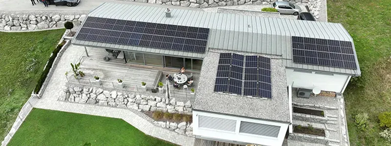 e-natura GmbH – Luftaufnahme eines modernen Einfamilienhauses mit mehreren Photovoltaikanlagen auf verschiedenen Dachflächen