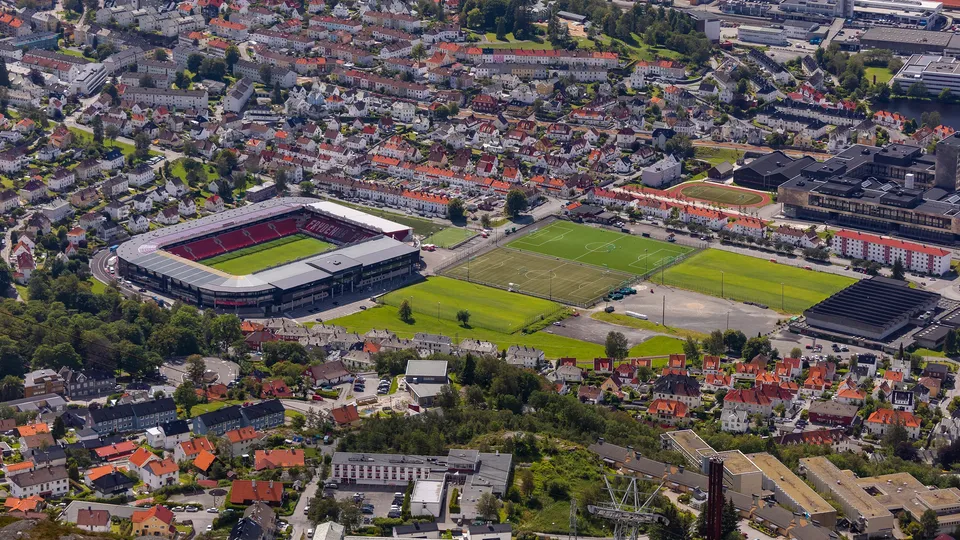 Utsikt over Brann Stadion i Årstad, Bergen, omgitt av boligområder og idrettsanlegg.