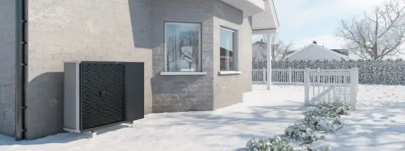 Modernes Hausäußeres mit Terrasse und Wärmepumpeneinheit im Winter.