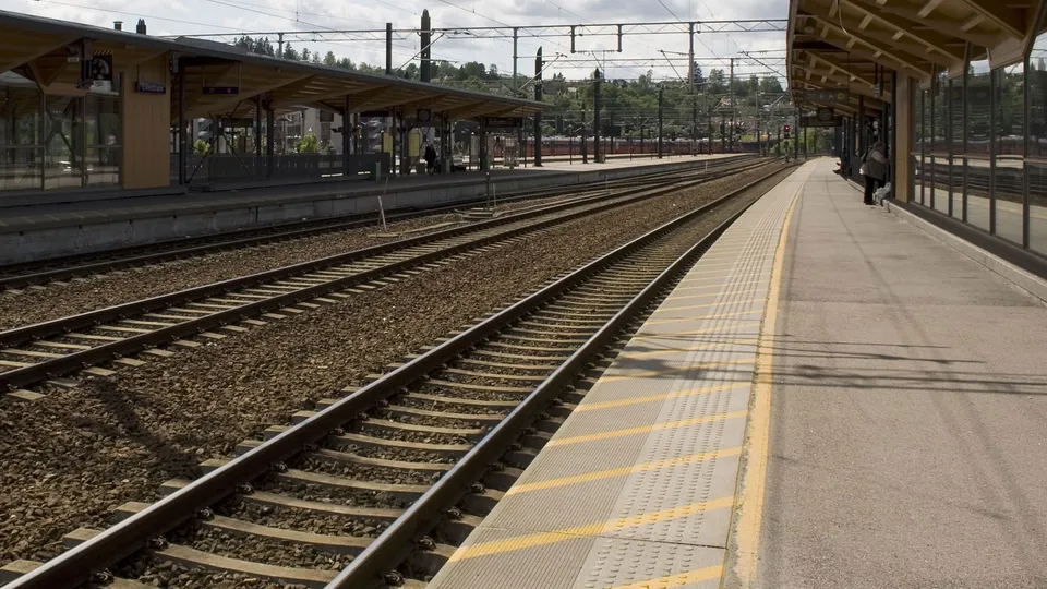 Tomme jernbanespor og plattform på togstasjon.