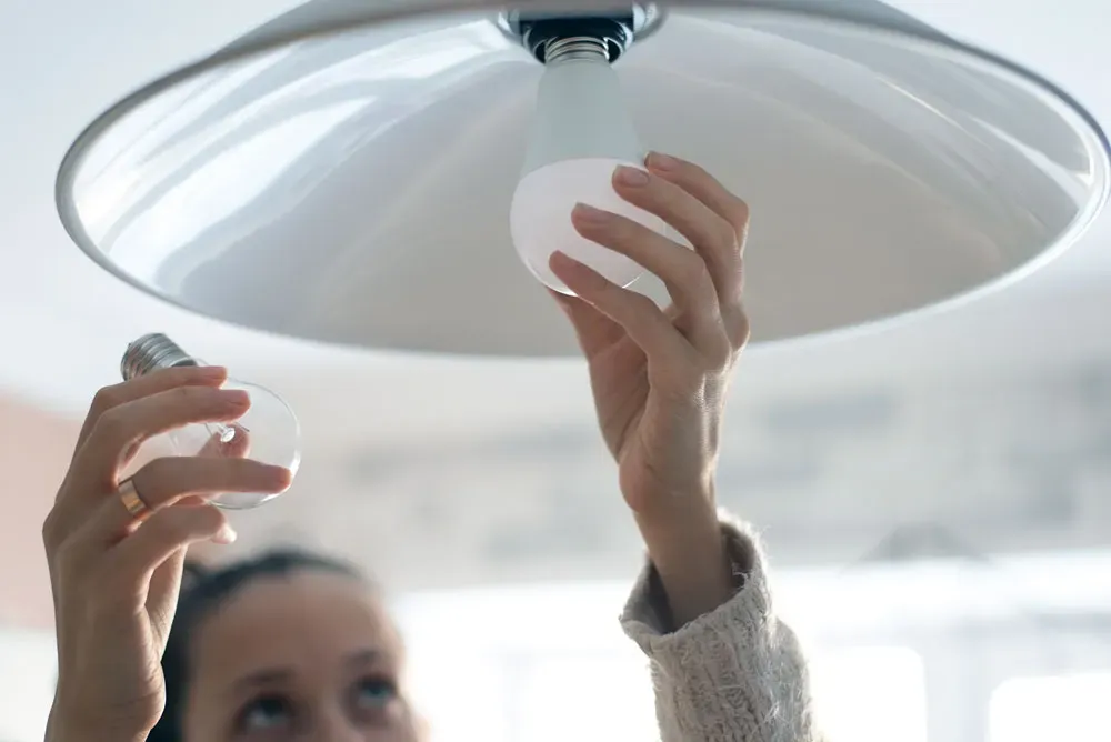 Person installerer LED-loftslampe.