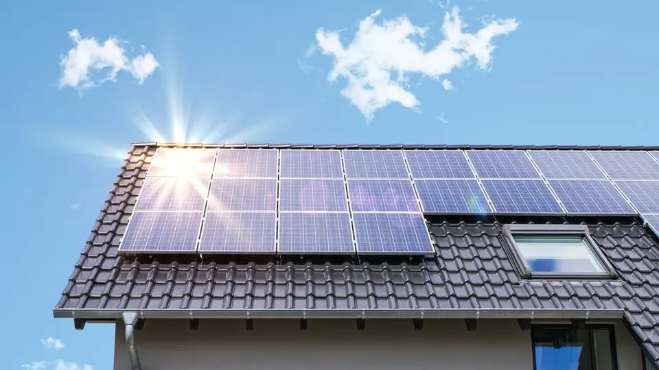 Pannelli solari installati su tetto residenziale sotto cielo soleggiato.