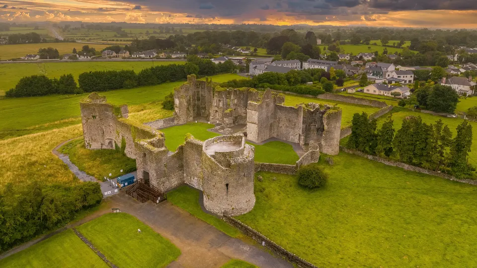 County Roscommon: view of ruined medieval castle surrounded by green fields and village.