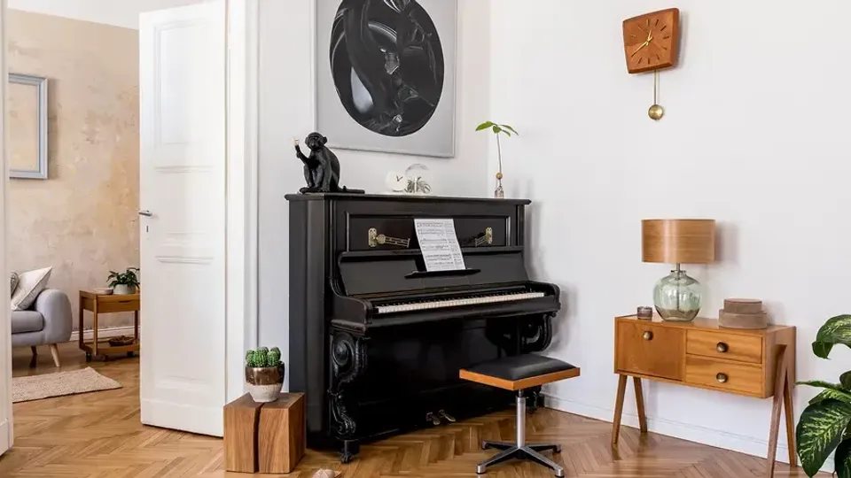 Svart pianino med träbänk i vardagsrum.