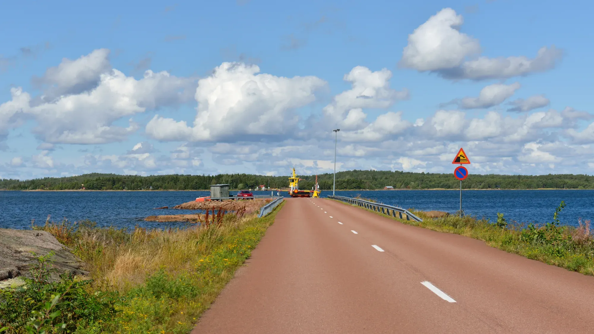 Bilväg som leder ut mot färja i Ålands skärgård.