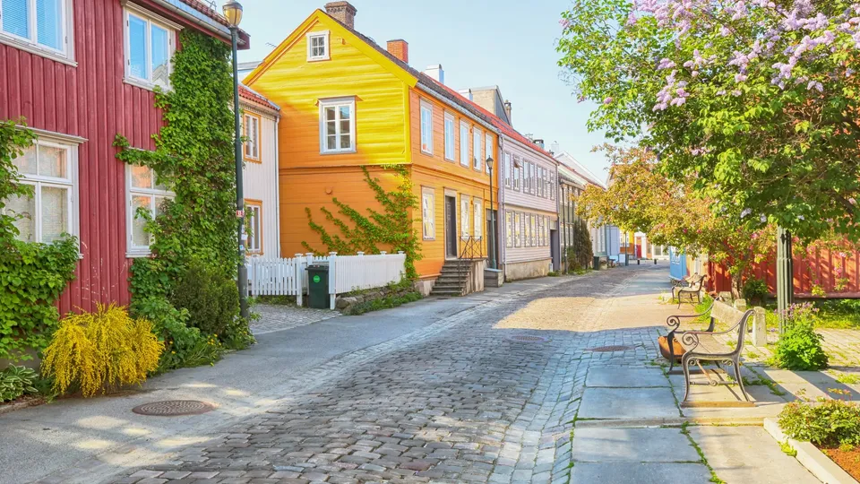 Eldre trehus langs en smal brosteinsgate i Trondheim, der adkomst kan være viktig ved valg av flyttebyrå
