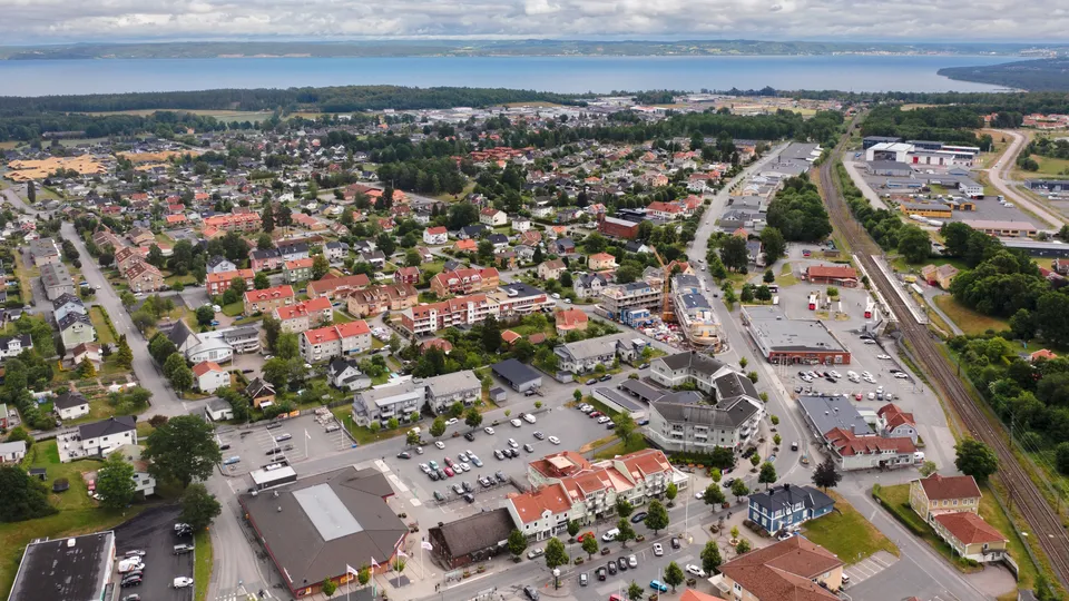 Flygfoto över Habo med hus, köpcentrum och sjö i bakgrunden.