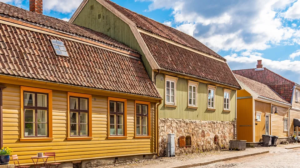 Fredrikstad - Rekke med fargerike trehus med takstein på en brosteinsgate.
